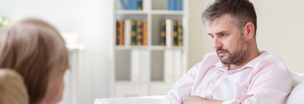 Alcohol Treatment -  A man sits with a therapist during his one on one session during his alcohol treatment to recover from alcoholism.